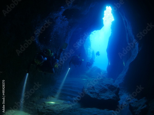 cave diving underwater scuba divers exploring caves and having fun ocean scenery sun beams and rays background