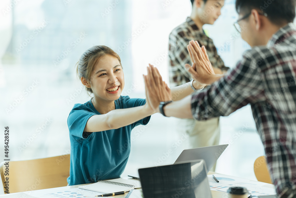 Fototapeta premium Group of asian young creative happy enjoy laugh smile and great success emotion teamwork people business startup entrepreneur casual brainstorm business meeting office background