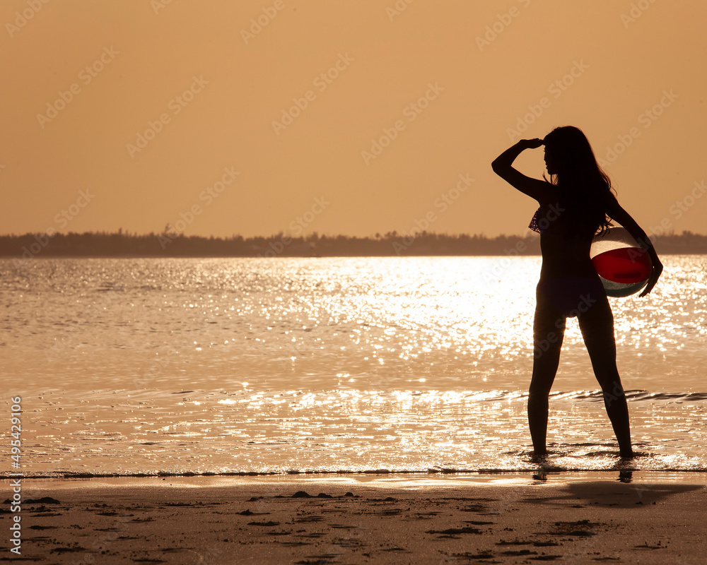 Asian woman standing in the ocean at sunrise