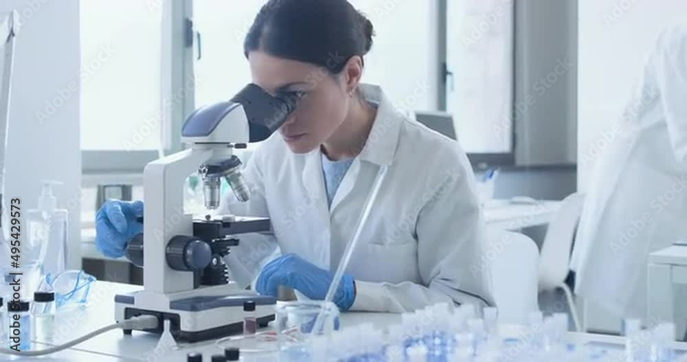 Researcher using a microscope in the clinical lab