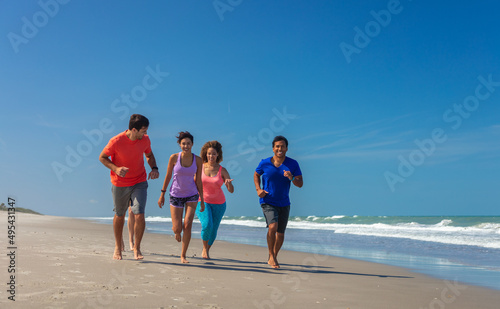Friends enjoying healthy Summer fun jogging on beach