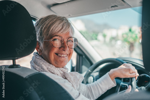Happy owner. Handsome mature woman sitting relaxed in his newly bought car looking at the camera smiling joyfully. One old senior driving and having fun.. © Daniel