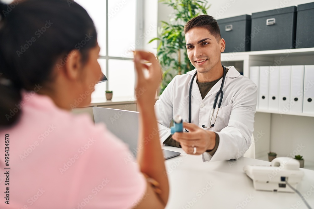 Man and woman doctor and patient having medical consultation holding inhaler at clinic Man and woman doctor and patient having medical consultation holding inhaler at clinic