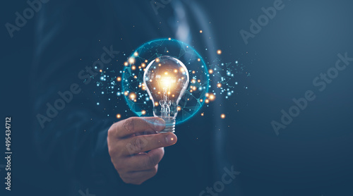 Hand of businessman holding illuminated light bulb with network connection line, idea, innovation and inspiration concept. concept creativity with bulbs that shine glitter.