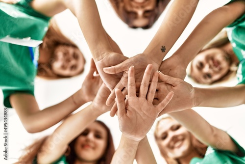 Group of young volunteers woman smiling happy with hands together at charity center.