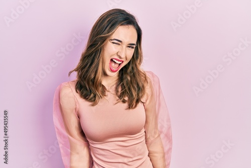 Young hispanic girl wearing casual clothes winking looking at the camera with sexy expression  cheerful and happy face.