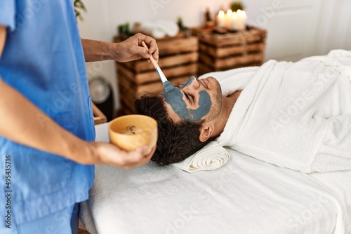 Man reciving facial treatment at beauty center. photo