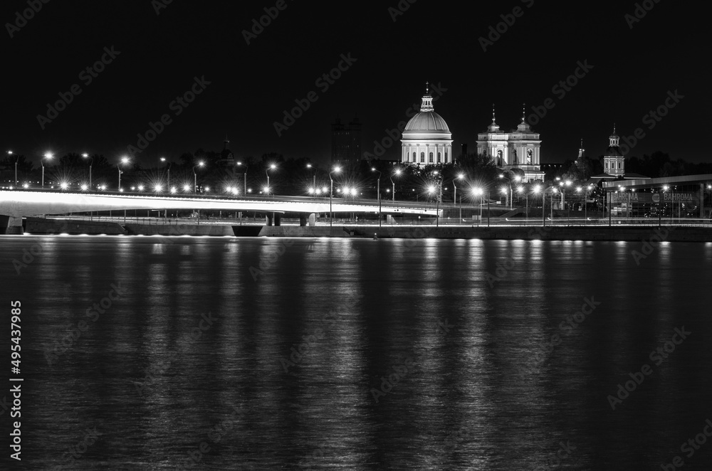 Alexander Nevsky Lavra in St. Petersburg, Russia. Alexander Nevsky Bridge across the Neva River and Sinopskaya Embankment. Night city landscape