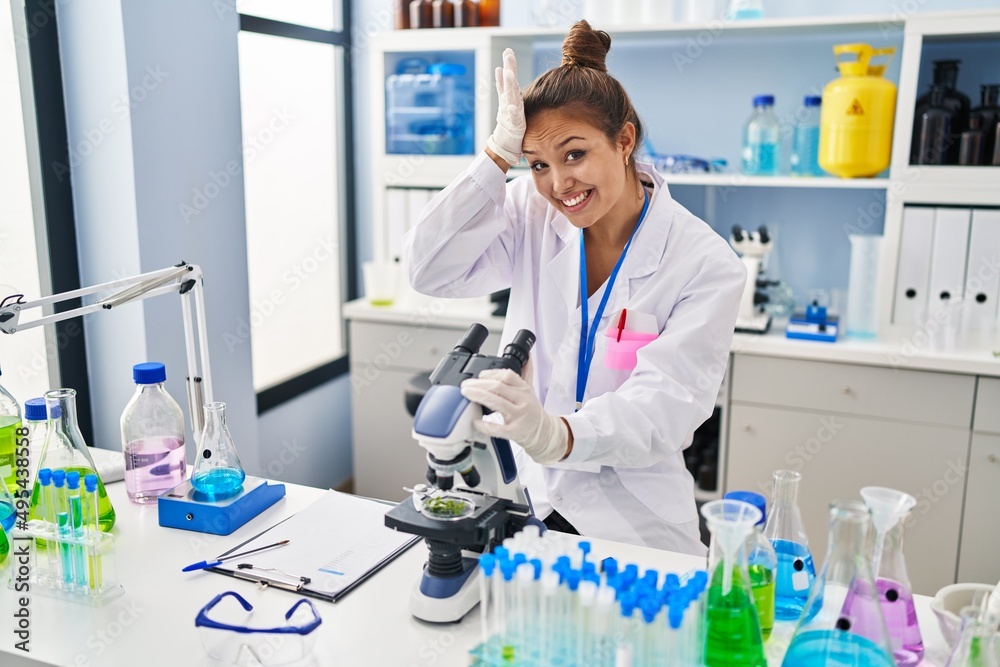 Young hispanic woman working at scientist laboratory stressed and frustrated with hand on head, surprised and angry face Young hispanic woman working at scientist laboratory stressed and frustrated with hand on head, surprised and angry face