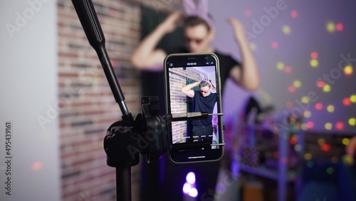 The guy dances on the phone camera and nothing works out for him. A view of the phone screen standing on a tripod. Social network. Blogger