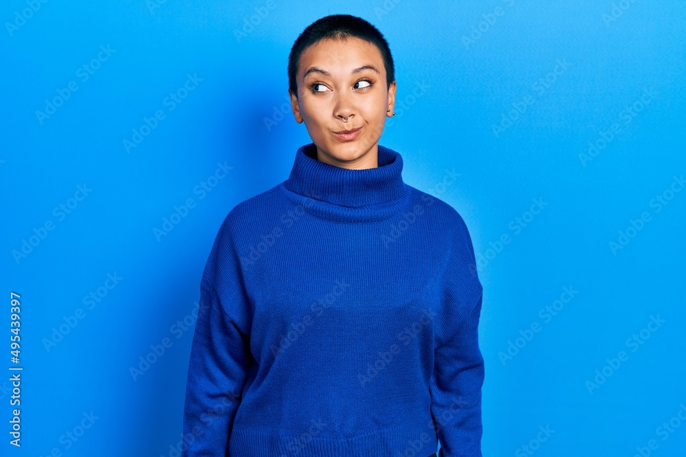 Beautiful hispanic woman with short hair wearing turtleneck sweater smiling looking to the side and staring away thinking. Beautiful hispanic woman with short hair wearing turtleneck sweater smiling looking to the side and staring away thinking.