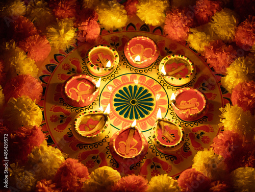 Diwali Rangoli with lit diyas and marigold flowers photo