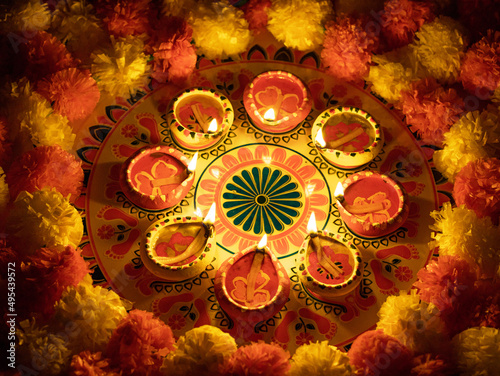 Diwali Rangoli with lit diyas and marigold flowers