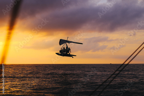 An hang glider flies over the sea at sunset. Summer activities. Sport. High quality photo