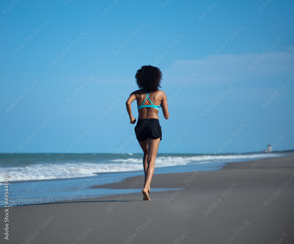 African American girl jogging on solo beach vacation African American girl jogging on solo beach vacation