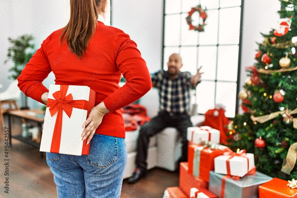 Young daughter giving present to senior father, celebrating christmas together at home Young daughter giving present to senior father, celebrating christmas together at home