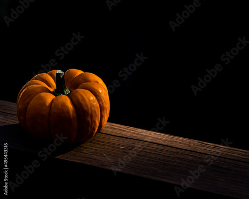 Orange pumpkin on brown wooden table