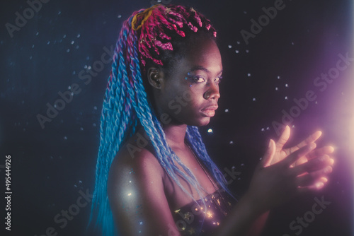 Portrait of young Black woman with colorful dreads in Nebula themed studio