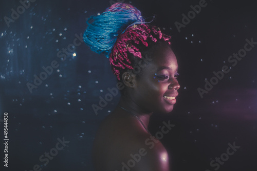 Portrait of young Black woman with colorful dreads in Nebula themed studio