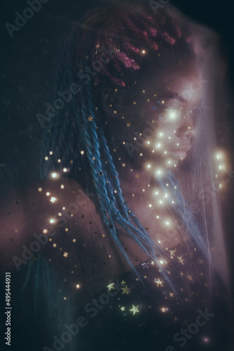 Portrait of young Black woman with colorful dreads in Nebula themed studio