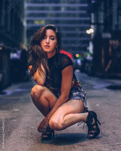 Portrait of young woman crouching in an alley photo