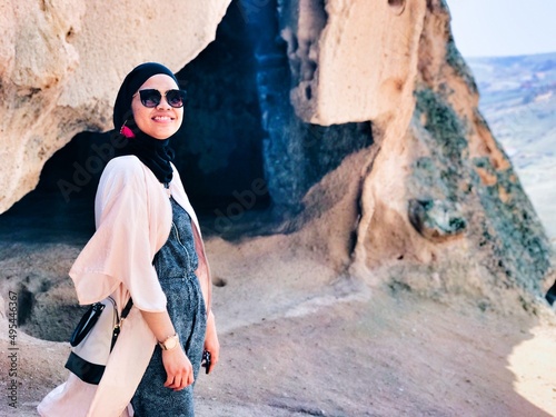 Smiling Malay woman with a hijab standing on seashore