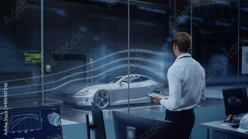 Engineering Research Agency Perform Aerodynamic Testing with a Modern Eco-Friendly Electric Sports Car in a Wind Tunnel. Chief Development Officer Works on a Tablet and Changes Testing Options. photo