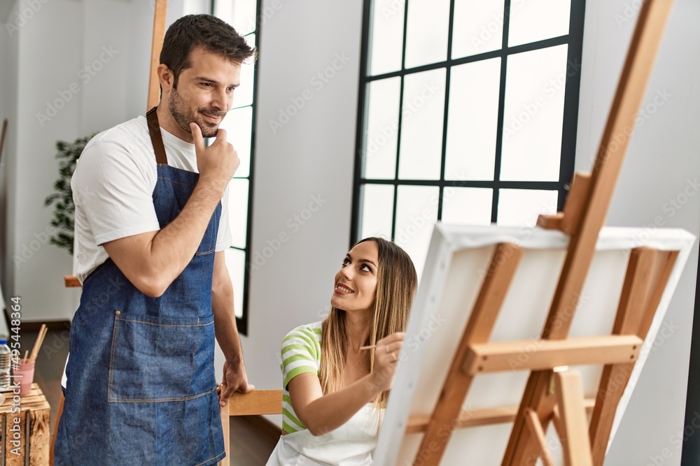 Student and teacher smiling happy painting at art studio. Student and teacher smiling happy painting at art studio.