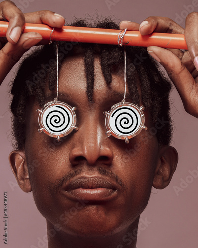 Young African man holding a prop to look hypnotized photo