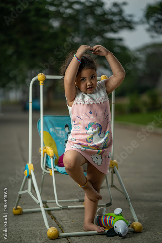 Young girl dancing ballet beside a kid swing chair outdoor photo