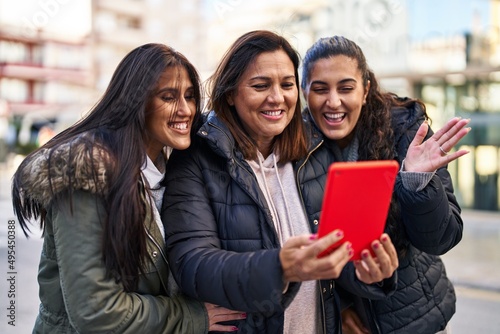 Three woman mother and daughters having video call at street