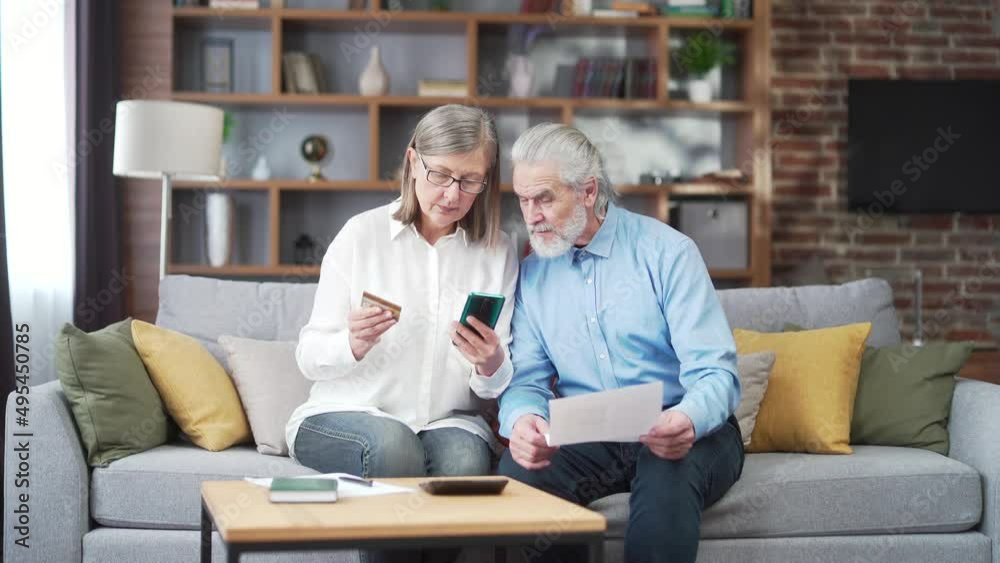 senior family couple, gray haired older pay, services enter data documents using application mobile smartphone credit card. Retirees elderly at home. utility bills, checks use computer smart phone senior family couple, gray haired older pay, services enter data documents using application mobile smartphone credit card. Retirees elderly at home. utility bills, checks use computer smart phone