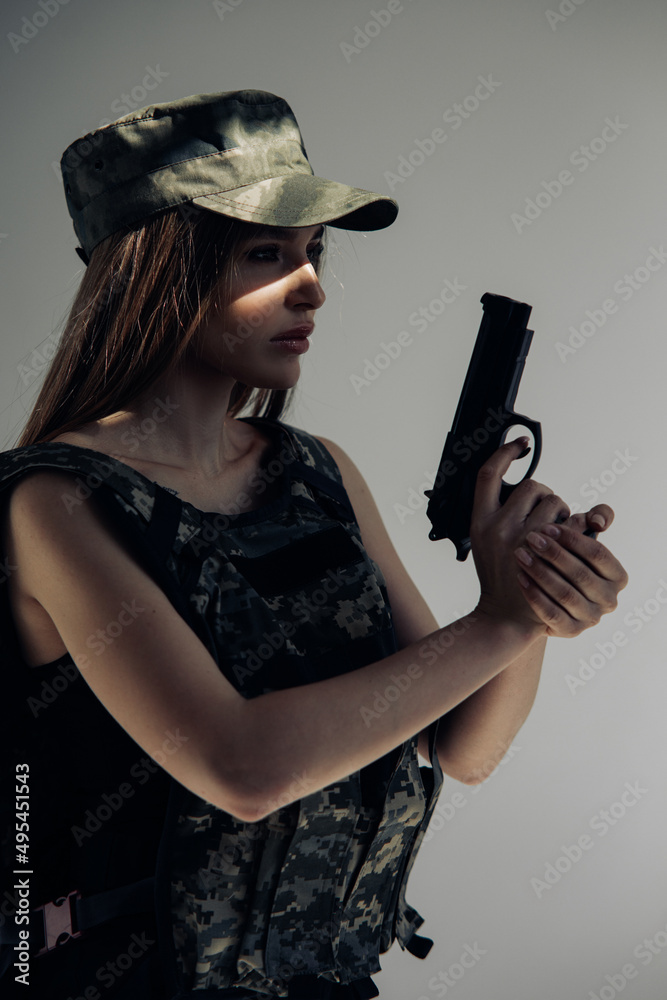 Portrait of young woman in uniform with handgun in her hand. Portrait of young woman in uniform with handgun in her hand.