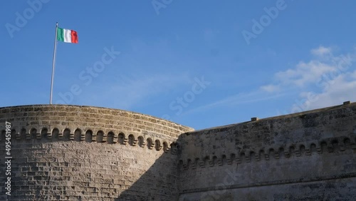 Italian flag waving in strong wind on a Castello Angioino fortress in Galipoli, Itali photo