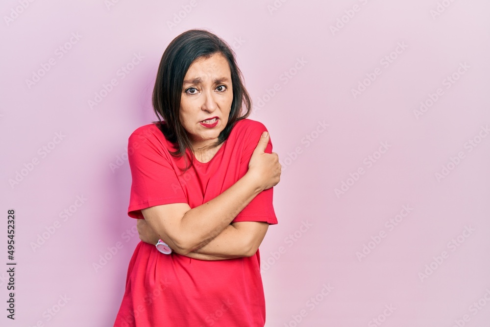 Middle age hispanic woman wearing casual clothes shaking and freezing for winter cold with sad and shock expression on face Middle age hispanic woman wearing casual clothes shaking and freezing for winter cold with sad and shock expression on face