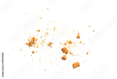 Scattered crumbs of vanilla chip butter cookies isolated on white background. Close-up view of brown crackers. Macro shot of yellow biscuit cake leftovers for your design photo
