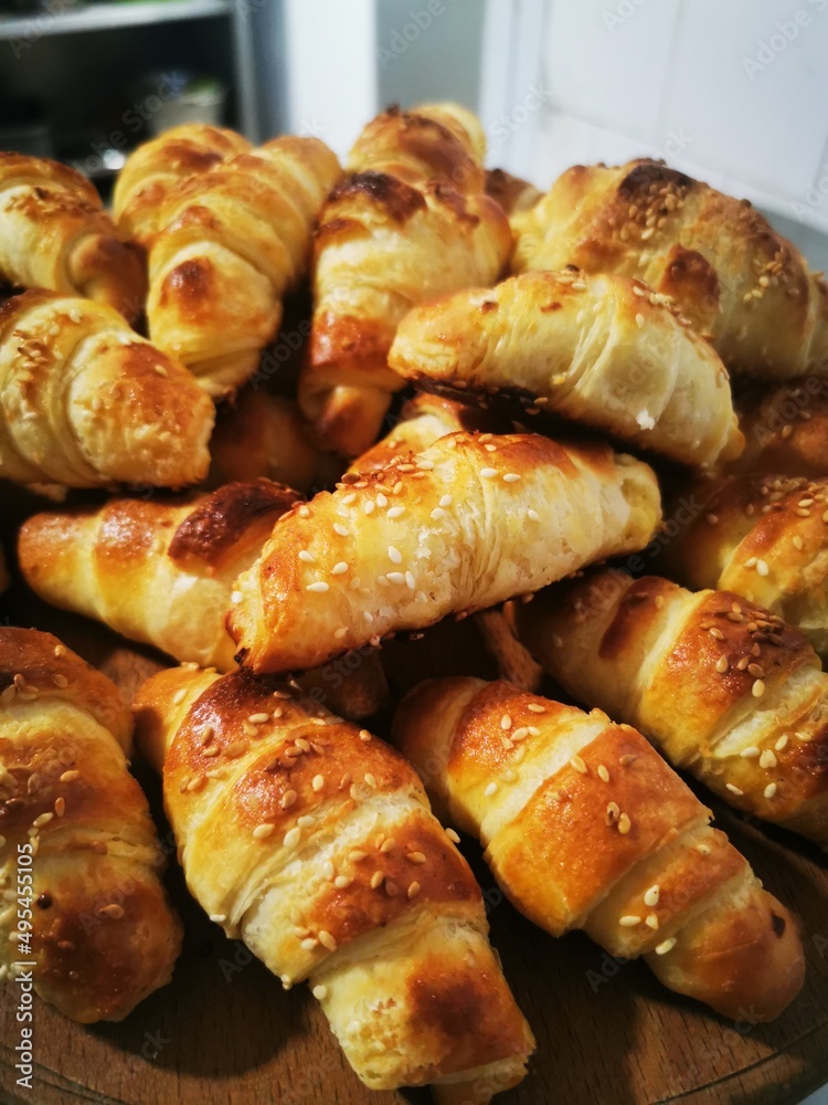 Fresh croissants covered with sesame on a wooden board. Homemade croissants in a traditional recipe Fresh croissants covered with sesame on a wooden board. Homemade croissants in a traditional recipe