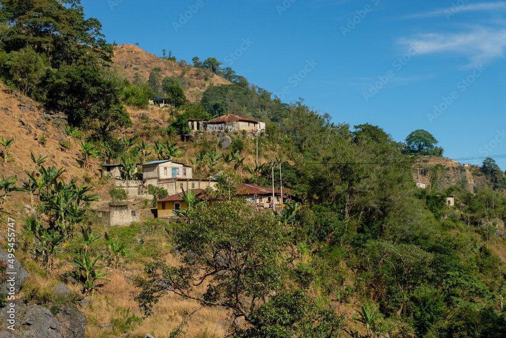 Houses perched on the hillside in rural countryside near Atsabe in Ermera district of Timor Leste, Southeast Asia