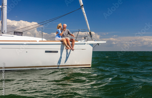 Loving American seniors sitting on deck of yacht