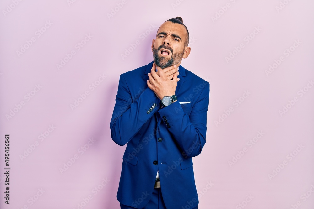 Young hispanic man wearing business suit and tie shouting suffocate because painful strangle. health problem. asphyxiate and suicide concept. Young hispanic man wearing business suit and tie shouting suffocate because painful strangle. health problem. asphyxiate and suicide concept.