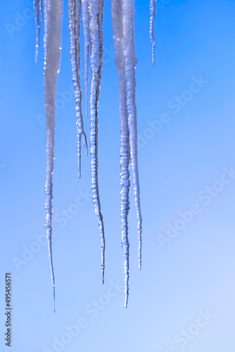 Pointed and dangerous icicles in winter. Ice on the roof. Cold weather