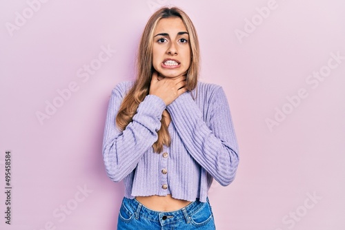 Beautiful hispanic woman wearing casual shirt shouting and suffocate because painful strangle. health problem. asphyxiate and suicide concept.