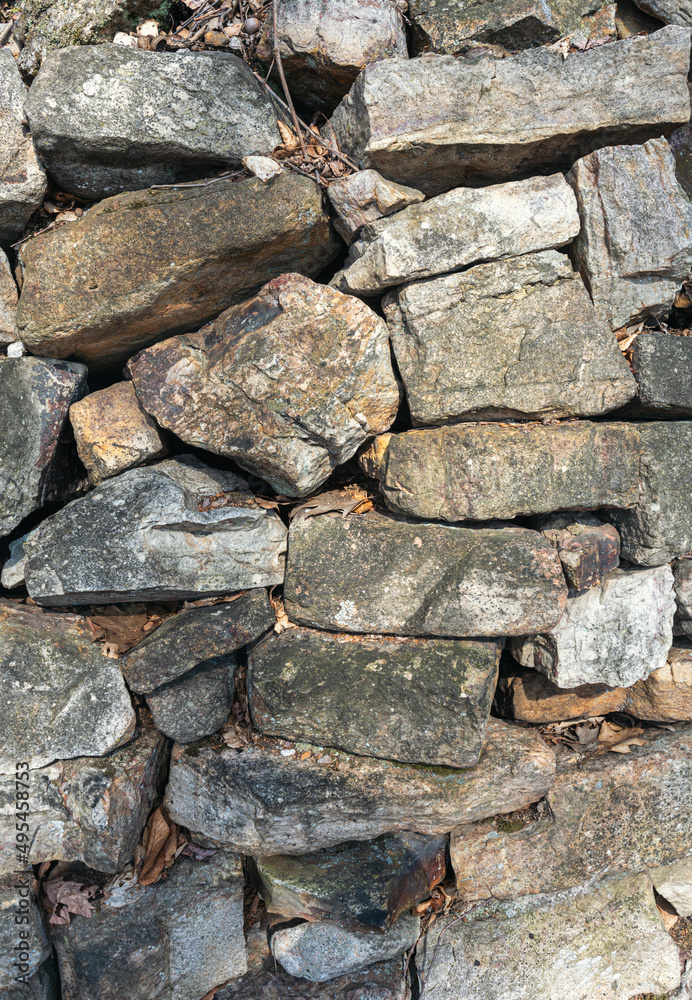 A section of a stone wall featuring randomly stacked stones.