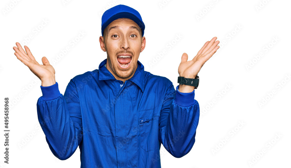 Bald man with beard wearing builder jumpsuit uniform celebrating crazy and amazed for success with arms raised and open eyes screaming excited. winner concept Bald man with beard wearing builder jumpsuit uniform celebrating crazy and amazed for success with arms raised and open eyes screaming excited. winner concept
