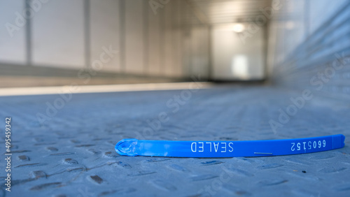 Broken plastic load seal on semi trailer floor. Empty big rig container with seal sitting on the floor. Transportation load safety concept. photo