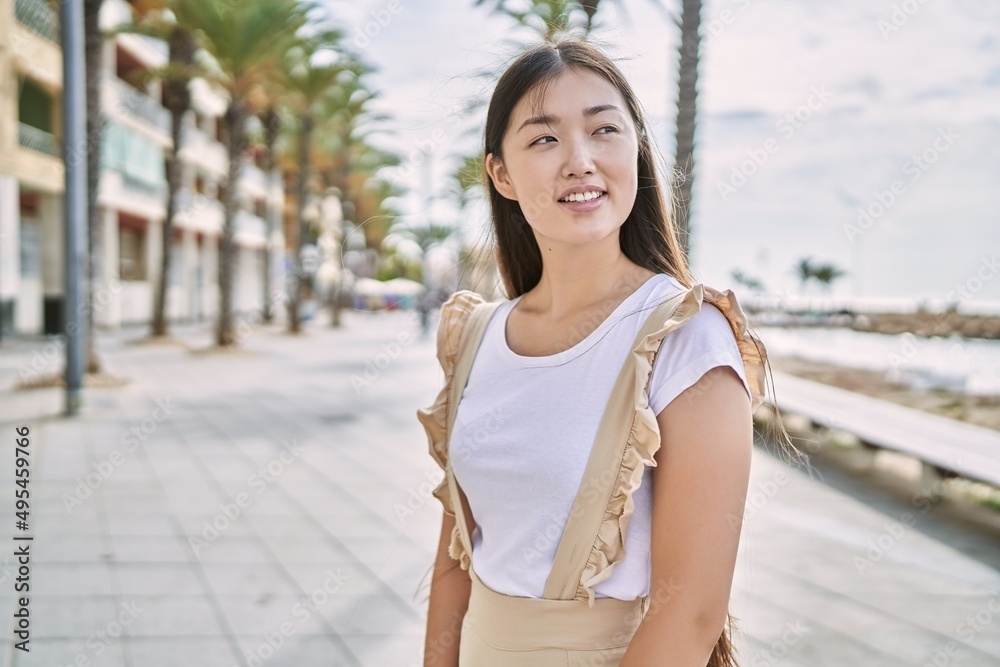 Young chinese girl smiling happy standing at the promenade