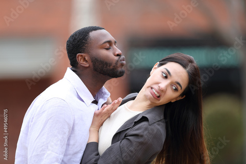 Man trying to kiss to a woman who is pulling him away