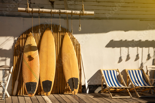 Wooden vintage Surfboard and Bamboo fence stands in the sand. © funfunphoto