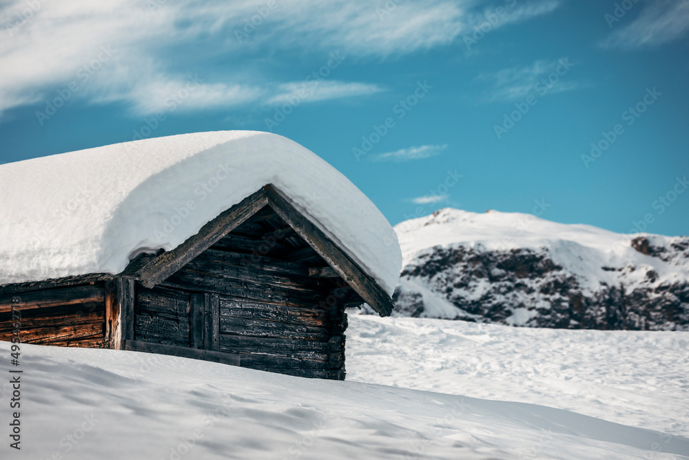 snow covered wooden cabin in the mountains