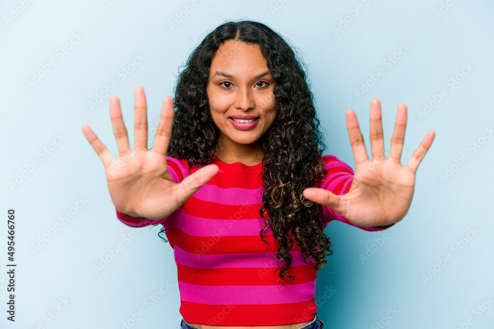 Young hispanic woman isolated on blue background showing number ten with hands. Young hispanic woman isolated on blue background showing number ten with hands.